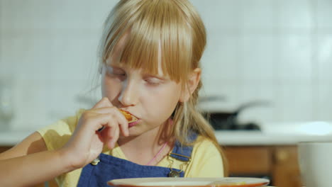 una joven come pizza en su cocina video 4k