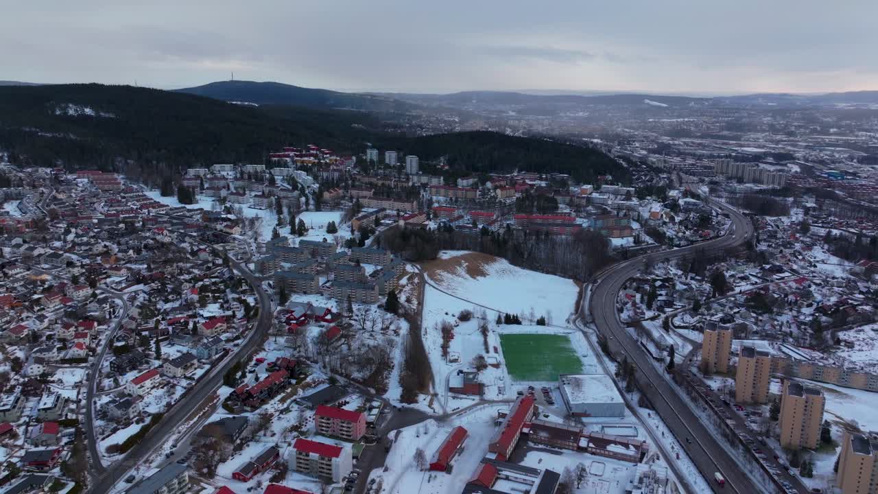 Bjerke Arvoll Tonsengagen Oslo Norge Norway Skikurs skisenter aerial drone cold cloudy winter day gray skies city tall neighborhood buildings landscape Arctic circle snowy cars highway forward motion