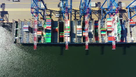 container ship in import export and business logistic, by crane, trade port, shipping cargo to harbor, aerial view from drone, international transportation, business logistics concept