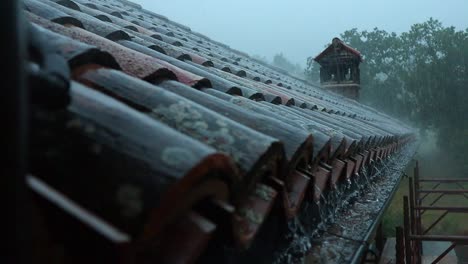 close up of water draining between the roof tiles of a house in the italian countryside during a storm