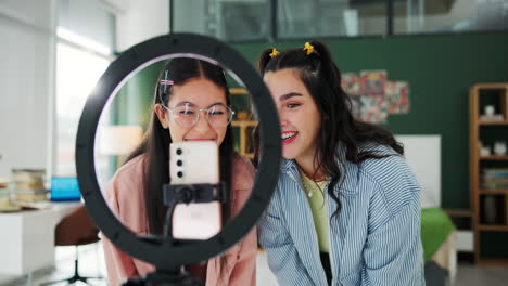 two women recording a video with a ring light and smartphone