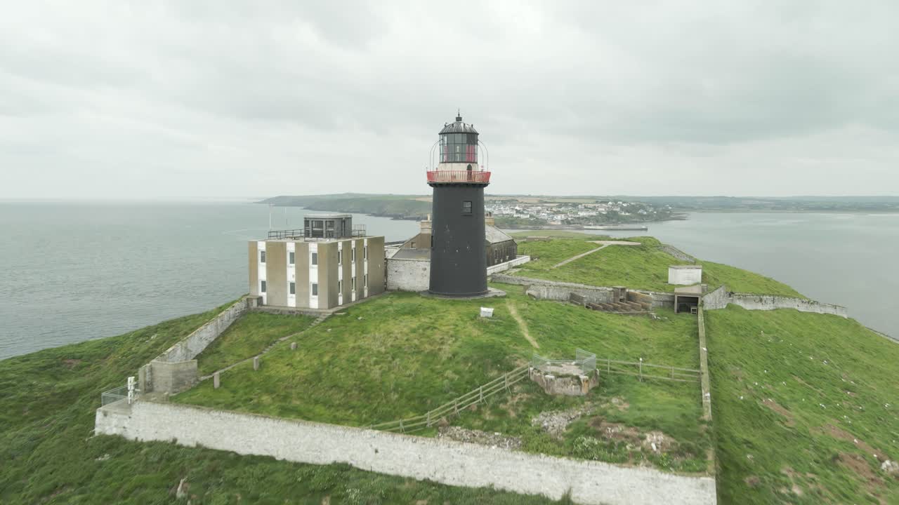 el avión no tripulado pasa por el faro de ballycotton en un día nublado en el condado de cork, irlanda