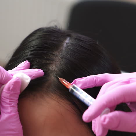 woman receives an injection in the scalp. problems of hair loss the concept of health.