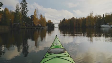 kayaking boat in calm lake surrounded by colorful fall trees, serenity concept, still shot