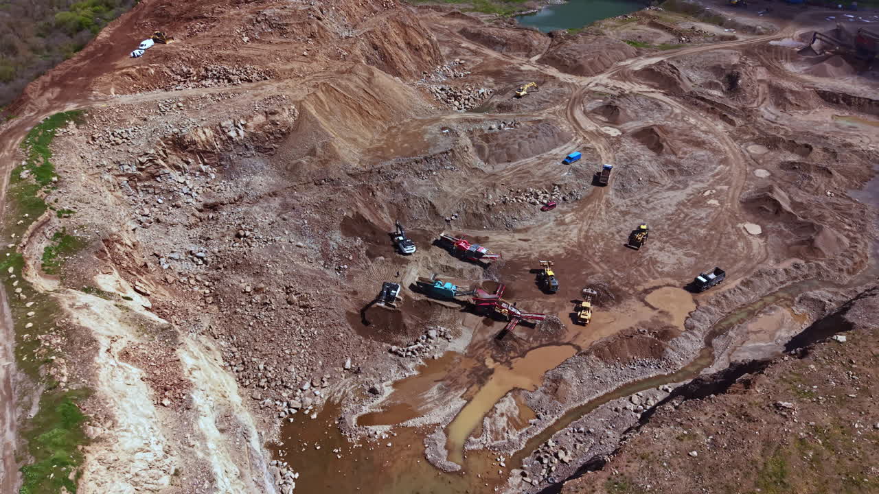 Construction site shows heavy machinery working on land development in a rural area during daylight