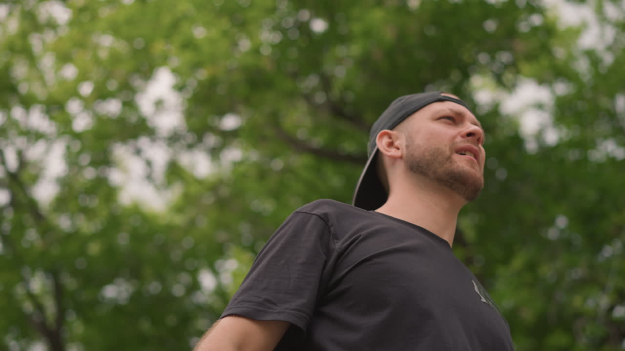 Person Looks Up At Treetops, Someone Observes Sky Through Green Canopy Overhead During Summer Days, Person Is Examining Open Sky Above With Lush Green Leaves Surrounding Them In Summer Months