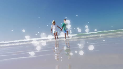 niños caucásicos jugando y corriendo manos a manos en la playa