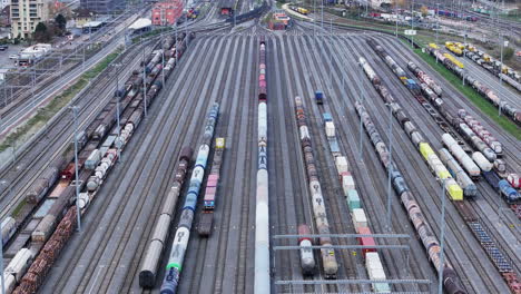 drone tilt shot of muttenz cargo train depot with the skyline of basel in the background