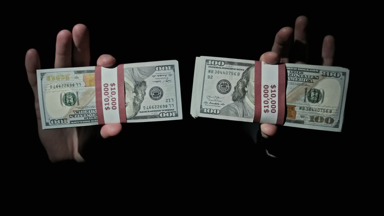 검은색 배경에 남성의 손에 10,000 미국 달러의 두 어리