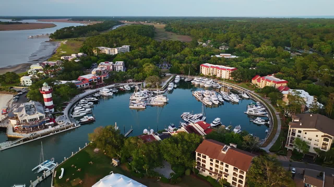 Overhead flyover of South Carolina harbor with curving boardwalk pier and boats, Harbour Town Pier South Carolina USA