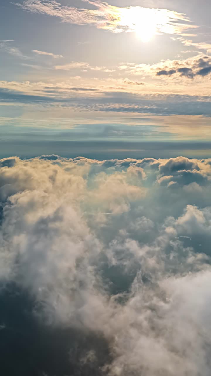 An aerial timelapse captures the breathtaking experience of flying high above a vast, fast-flowing sea of fluffy white clouds as the bright sun illuminates the sky, creating a heavenly scene.