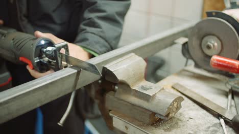 trabajador de la industria de piezas metálicas con sierra eléctrica
