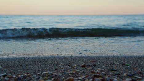 Nahaufnahme-Von-Meereswasserwellen,-Die-Am-Abend-Am-Sandstrand-Planschen.-Sandstrand-Makro