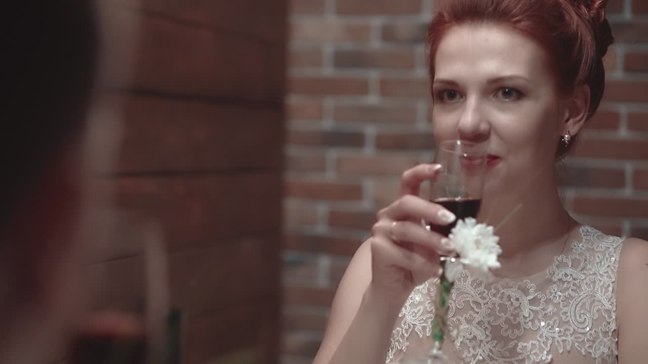 una joven pareja sentada en un restaurante bebiendo vino