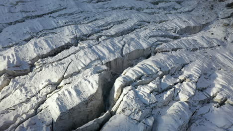 Toma-Aérea-Cinematográfica-Giratoria-De-Muchas-Grietas-A-Través-Del-Glaciar-Ak-sai