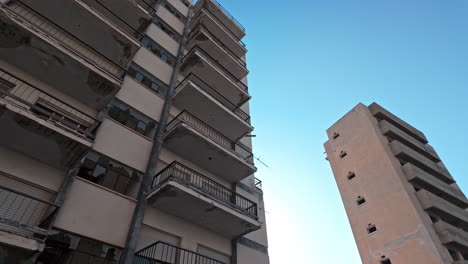tall abandoned apartment buildings in varosha, cyprus, with a clear blue sky in the background