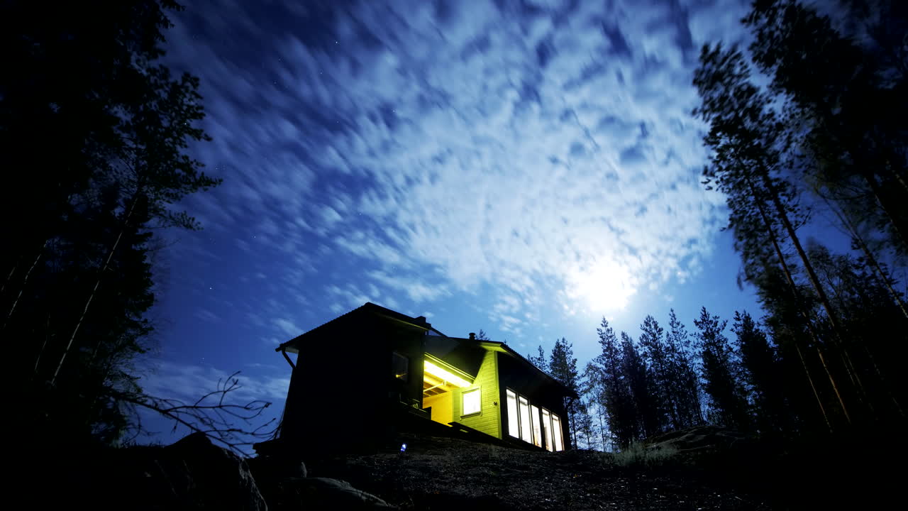 lapso de tiempo de la luna llena desde la cabaña en el bosque en finlandia por la noche