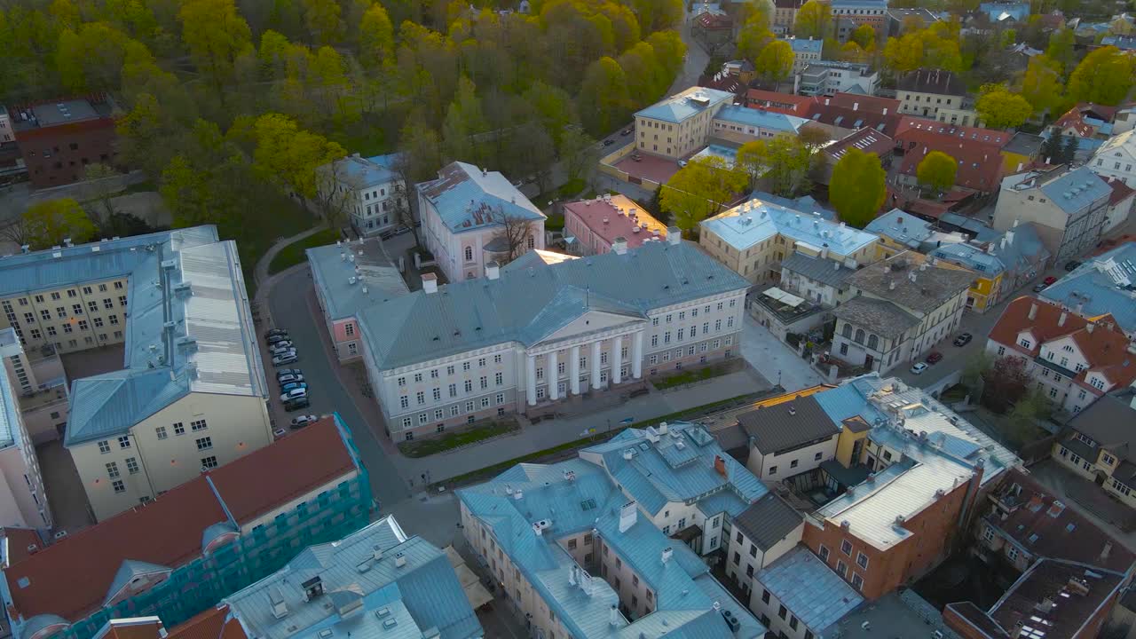 Overlooking University of Tartu main hall with white columns, Estonia historic architecture. Rotating around charming old city during calm evening. High angle urban environment with historical setting