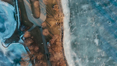 fotografia aérea da península com trilhas para caminhadas cercadas por um lago congelado azul gelado