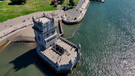 Drone-shot-flying-over-and-tilting-down-at-Belem-tower-in-Lisbon,-Portugal