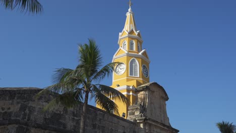 cartagena, colombia torre del reloj enclavada en medio de la arquitectura histórica, enmarcada por palmeras y bajo un cielo azul claro