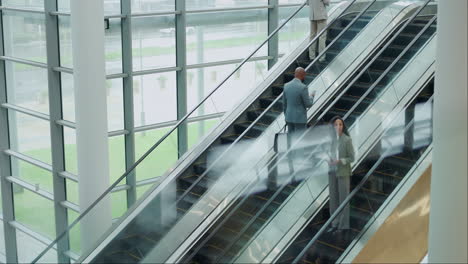 escaleras mecánicas, oficinas y gente de negocios en el viaje.
