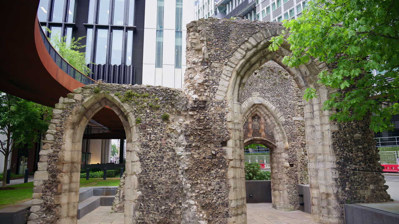 Close-up shot of ancient Roman wall ruins with modern office buildings located in the London Wall Place garden