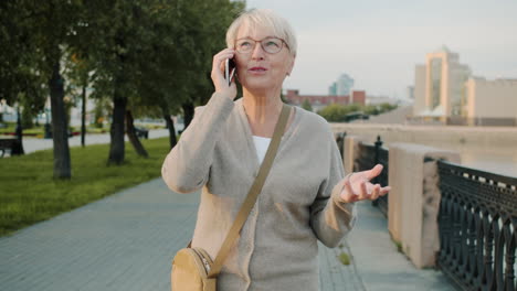 older woman talking on phone outdoors