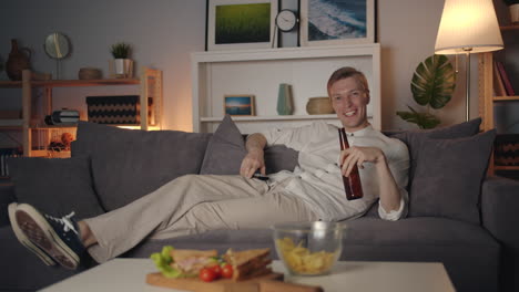 hombre relajándose en casa viendo la televisión