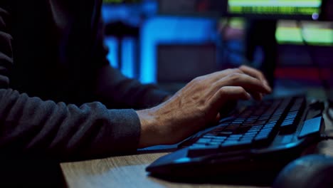 cierre de las manos masculinas tocando, escribiendo y enviando mensajes de texto en el teclado de la computadora por la noche mientras se programa