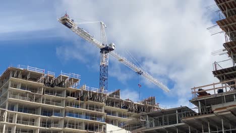 Construction-crane-building-residential-condominium-development-in-downtown-city