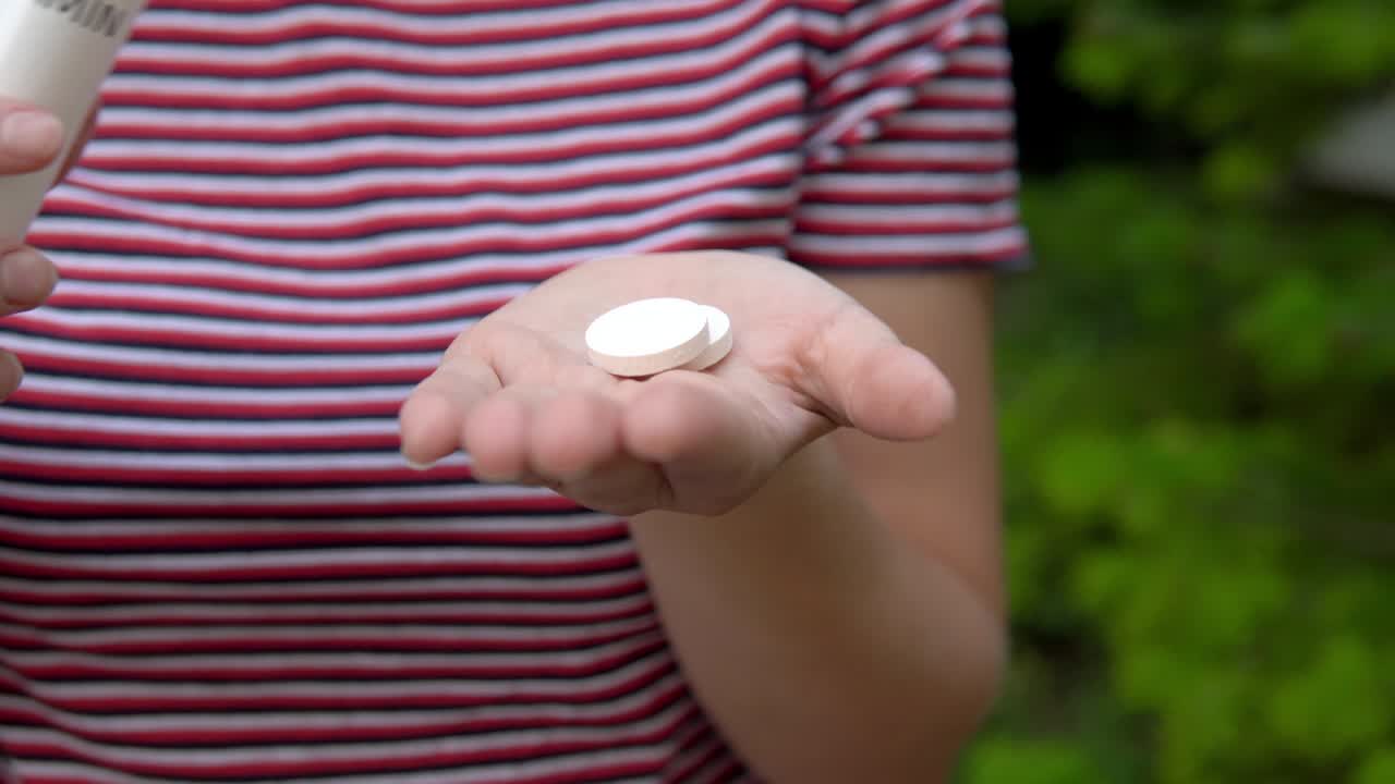 The girl holds a capsule in her hand and takes out vitamins from it into the palm of her hand. Maintaining immunity. Healthy lifestyle.