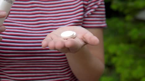 the girl holds a capsule in her hand and takes out vitamins from it into the palm of her hand. maintaining immunity. healthy lifestyle.