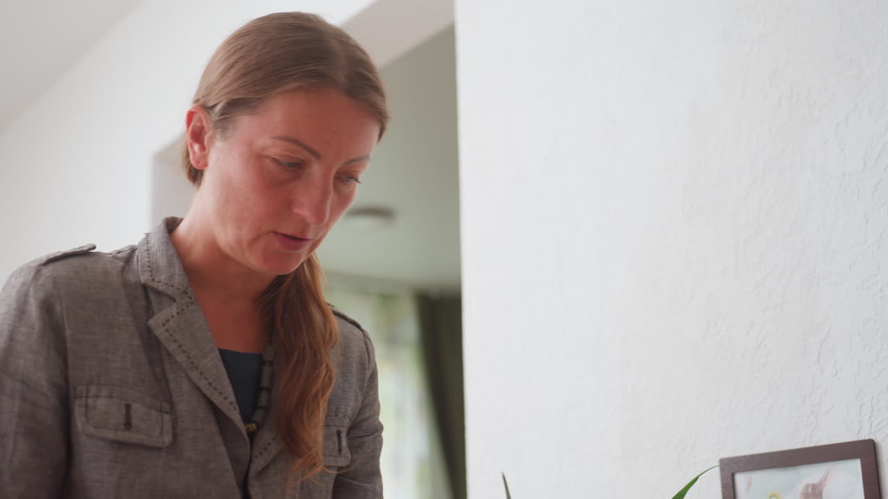 Side view of kindergarten teacher instructing child to leave drawing board, calm expression showing patience and focus, gentle classroom interaction highlighting education