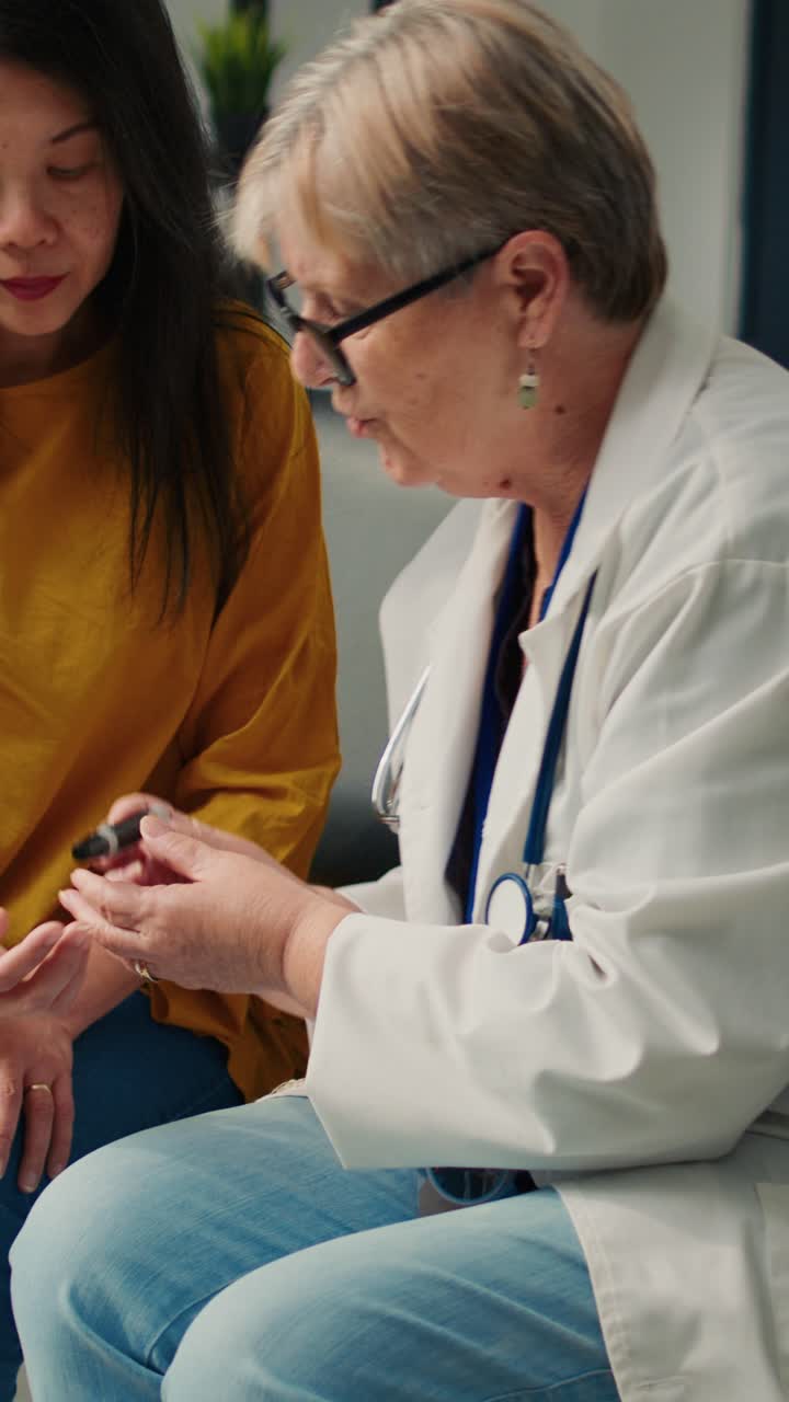 Vertical video: Asian patient doing diabetes consultation with glucometer instrument