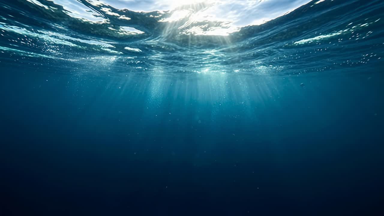 Raggi di sole che penetrano la superficie calma dell'oceano, illuminando lo spazio sottomarino blu intenso con una pacifica atmosfera naturale