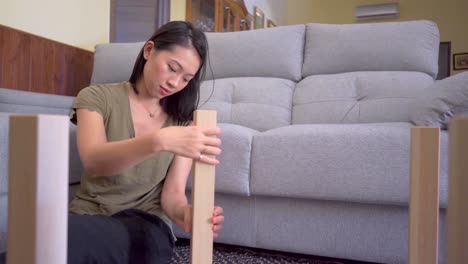 asian woman assembling table in living room