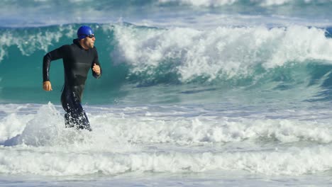 male surfer running in the beach