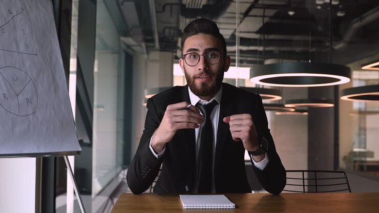 Palestrante masculino sorridente e agradável de etnia do Oriente Médio gravando vídeo educacional.