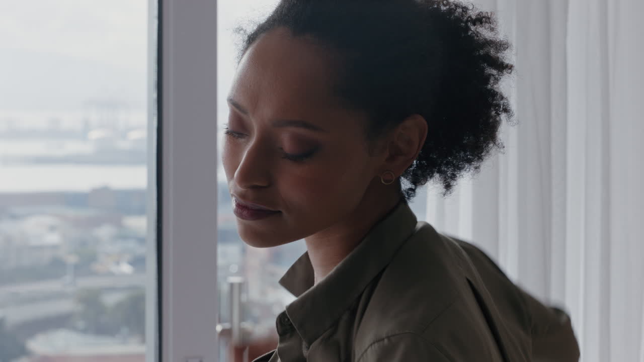 beautiful african american woman dressing getting ready late for work looking out window enjoying fresh new day feeling rested