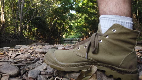 footstep-in-from-of-camera-on-a-rocky-path-with-a-beautiful-creek-in-the-background