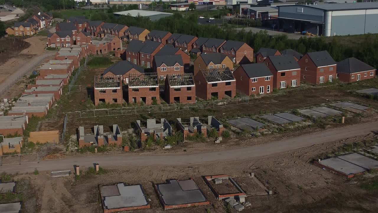 Residential housing framework aerial zoom in view towards unfinished rooftop development on urban building site real estate