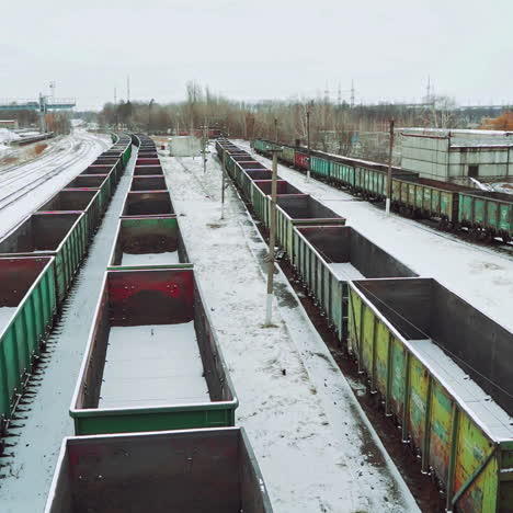 empty shipping containers are located at an abandoned railway station in the countryside against the background of snow and forest. aerial view.