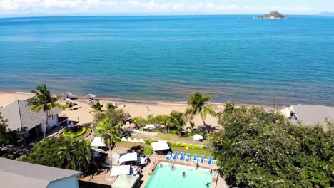 vista aérea del lago malawi con drones, la gente disfruta de la piscina en el resort de playa