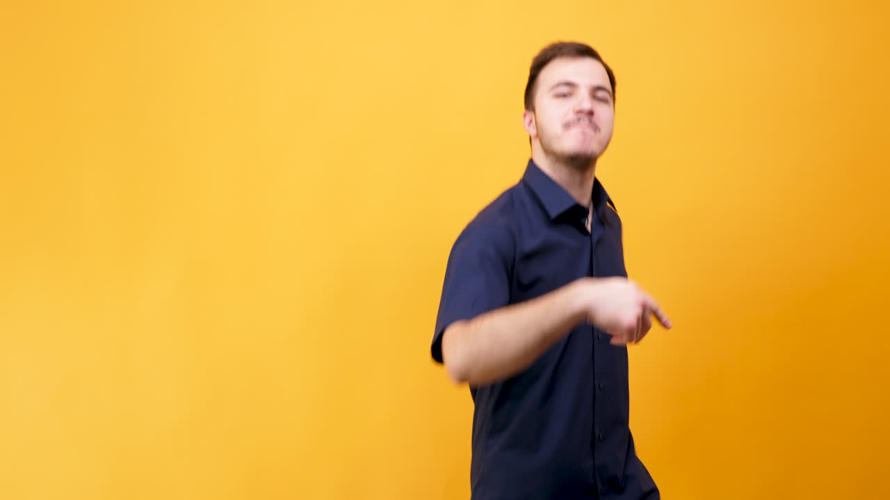 Man pointing and dancing on yellow background