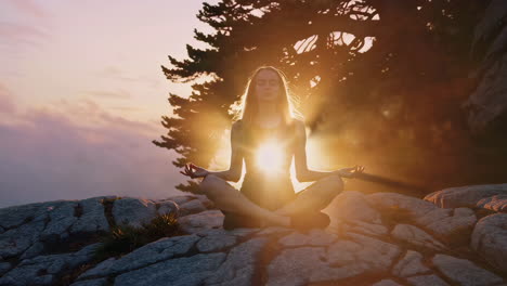 woman meditating at sunset in mountains