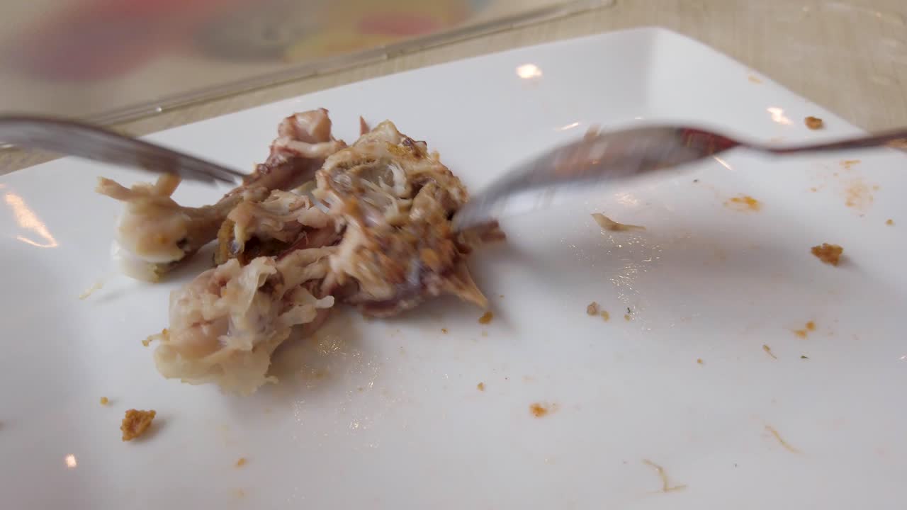 Sorting leftover bones in plate of finished fried chicken meal