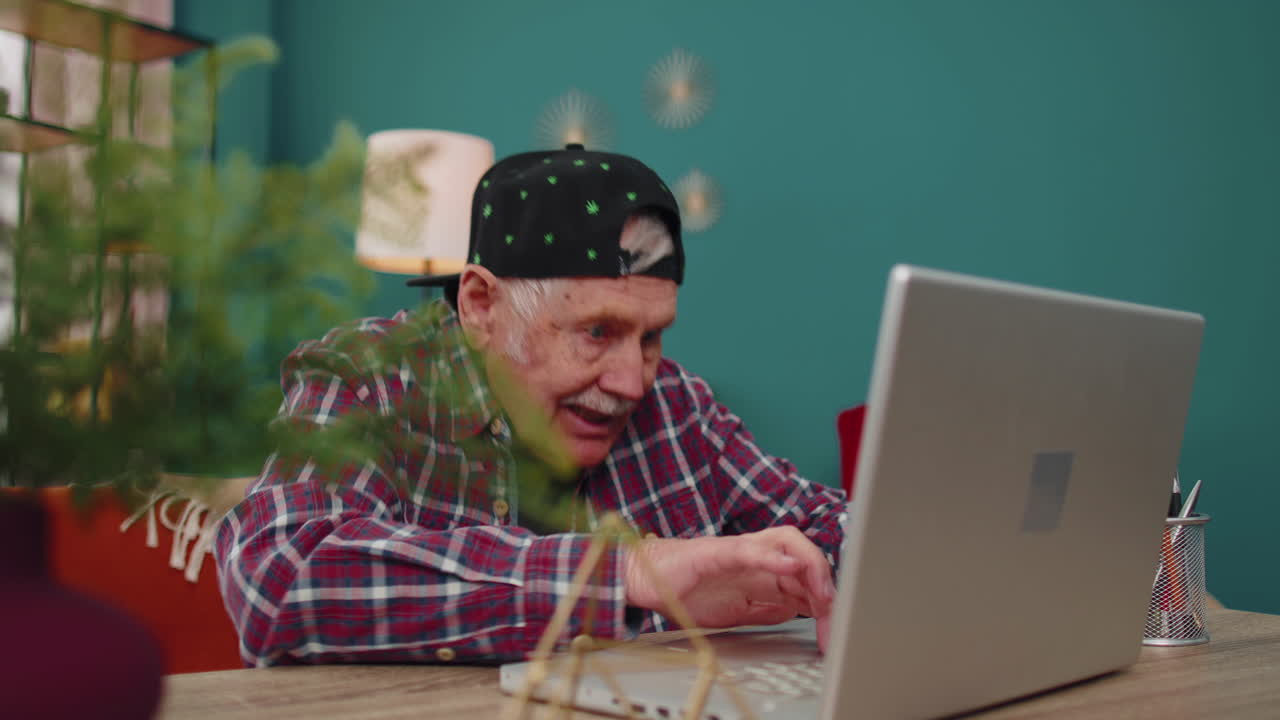 노트북 컴퓨터에서 컴퓨터 비디오 게임을 하는 할아버지, 승리, 축하, 행복하게 미소