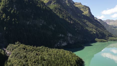 Montañas-Gigantescas-Se-Postran-En-El-Lugar-Creando-Un-Hito-Llamativo-Para-Que-Los-Excursionistas-Experimentados-Escalen-Estas-Colinas-Rocosas-Y-Empinadas,-Un-Lago-De-Agua-Clara-Y-Tranquila-Con-Reflejos-De-Nubes-En-él,-Pacífico.