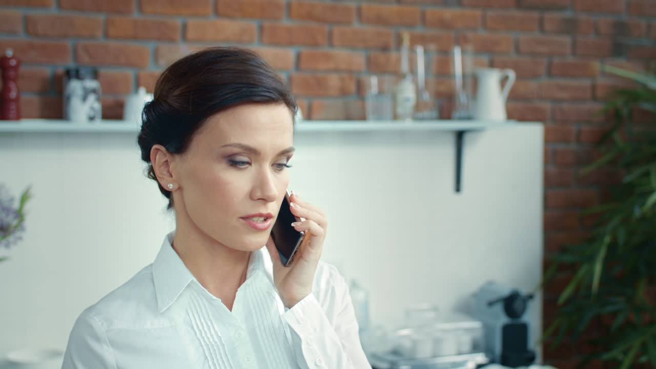 우아한 사업가 여성이 비즈니스 미팅을 계획하고 젊은 여성이 전화를 하고 있습니다.